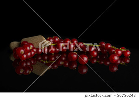 Fresh red currant isolated on black glass Fresh red currant isolated on black glass 56750248