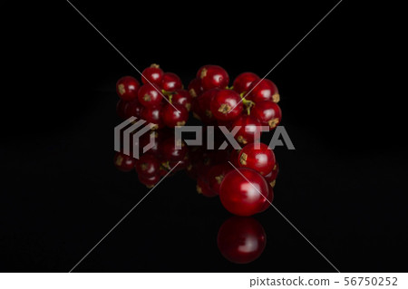 Fresh red currant isolated on black glass Fresh red currant isolated on black glass 56750252