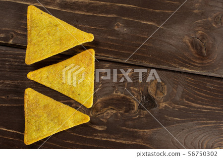 Tortilla cheese chips on brown wood 56750302