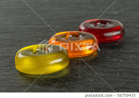 Colourful hard candy on grey stone Colourful hard candy on grey stone 56750435