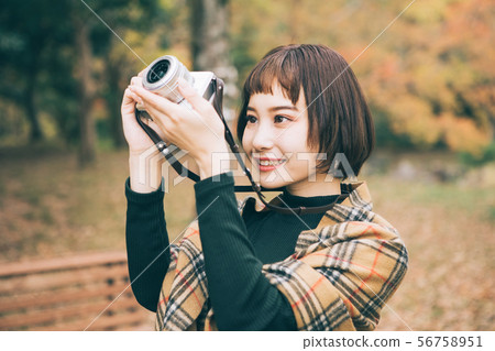 拍秋葉的照片婦女 拍秋葉的照片婦女 56758951