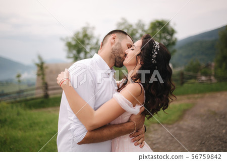 Beautiful wedding couple in Carpathian mountains. Handsome man with attractive woman. Bride spin Beautiful wedding couple in Carpathian mountains. Handsome man with attractive woman. Bride spin 56759842