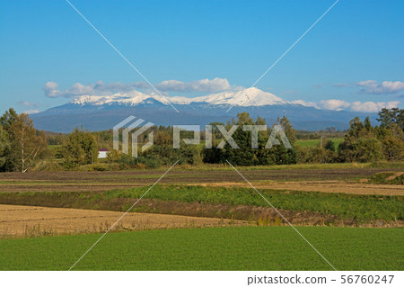 Snow covered mountain range and blue sky Daisetsuzan 56760247