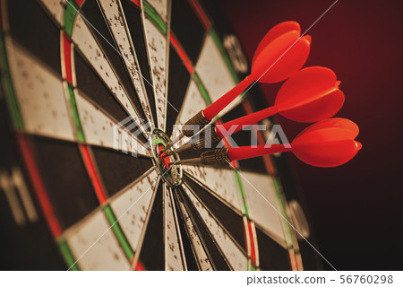 Three darts in the center bulls eye of a target Three darts in the center bulls eye of a target 56760298