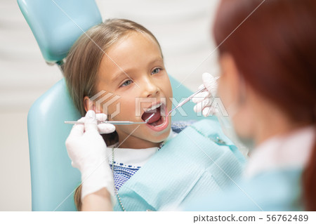 Blue-eyed girl opening mouth wide while visiting dentist Blue-eyed girl opening mouth wide while visiting dentist 56762489