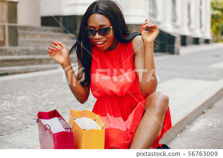 Beautiful black girl with shopping bags in a city Beautiful black girl with shopping bags in a city 56763009