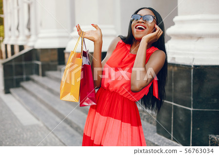 Beautiful black girl with shopping bags in a city 56763034