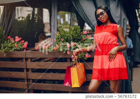 Beautiful black girl with shopping bags in a city Beautiful black girl with shopping bags in a city 56763172