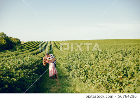 Beautiful couple spend time on a summer field Beautiful couple spend time on a summer field 56764286