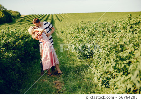 Beautiful couple spend time on a summer field Beautiful couple spend time on a summer field 56764293