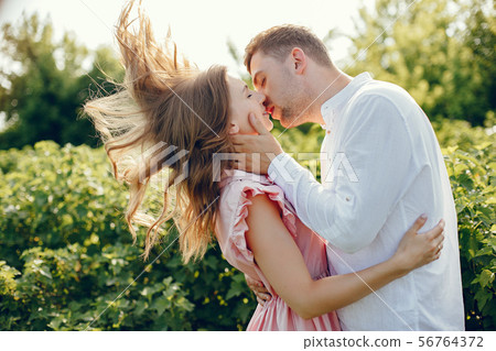 Beautiful couple spend time on a summer field Beautiful couple spend time on a summer field 56764372