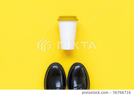 Black boots and a bamboo cup with a plastic lid for coffee to go Black boots and a bamboo cup with a plastic lid for coffee to go 56766716