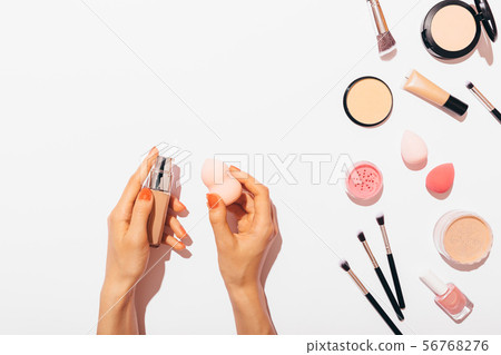 Applying foundation on makeup sponge 56768276