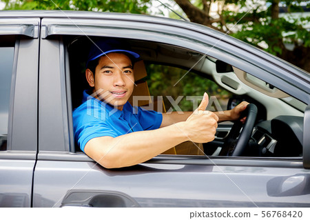 Delivery driver driving van with parcels on seat 56768420