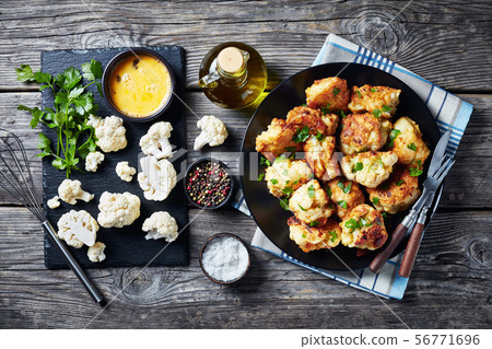 Fried Cauliflower florets on a black plate 56771696