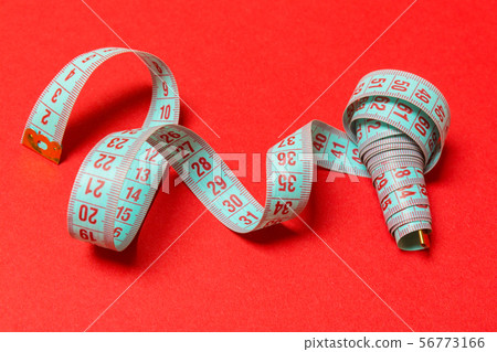 Perspective view of spiral measuring tape on red 56773166