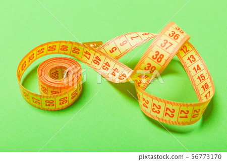 Close up of tangled measuring tape on green Close up of tangled measuring tape on green 56773170