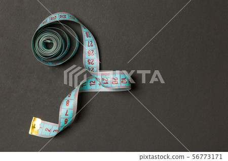 Top view of measure tape curtailed into a spiral 56773171