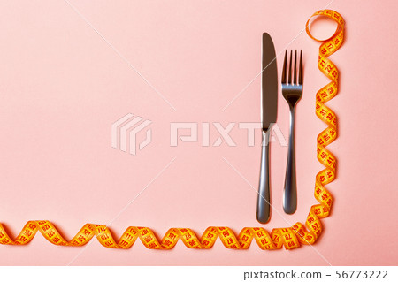 Top view of fork and knife and curled measuring 56773222