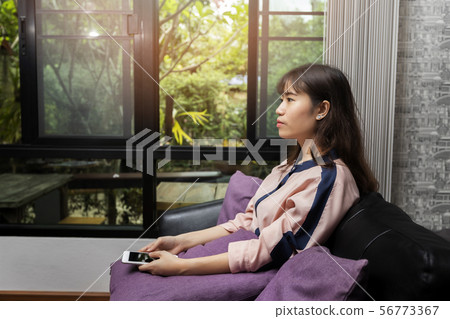 Beautiful young Asian woman using mobile phone 56773367
