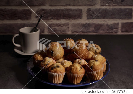group of muffins next to a cup of milk group of muffins next to a cup of milk 56775263