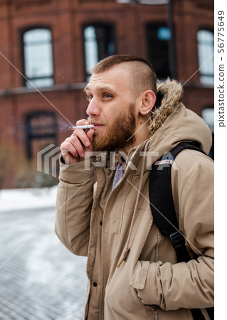 A young beard man walks in a winter coat  A young beard man walks in a winter coat  56775649