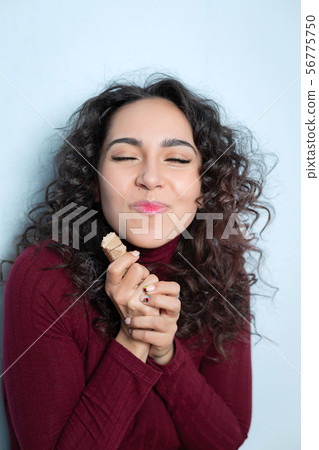 Girl eats a chocolate and shows emotions Girl eats a chocolate and shows emotions 56775750