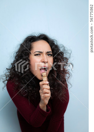 Girl eats a chocolate and shows emotions Girl eats a chocolate and shows emotions 56775862