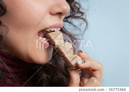 Girl eats a chocolate and shows emotions Girl eats a chocolate and shows emotions 56775866