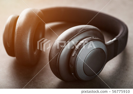 Wireless black headphones on a dark background 56775910