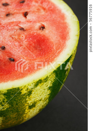 Half of tasty and ripe red watermelon on a black 56775916