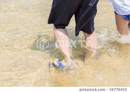 Senior walking on the beach 56776450