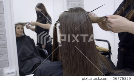 Cute girl with long brunette hair hairdresser doing hair lamination in a beauty salon. concept of 56776839