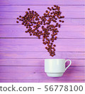 Grain of coffee in the form of a heart over a cup. 56778100