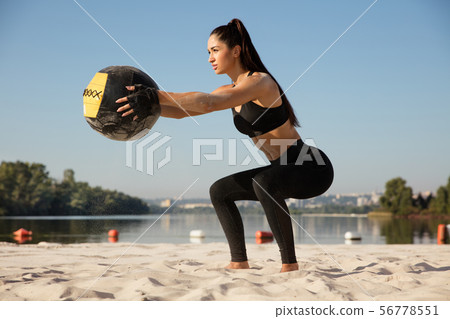 Young healthy female athlete doing workout at the beach Young healthy female athlete doing workout at the beach 56778551