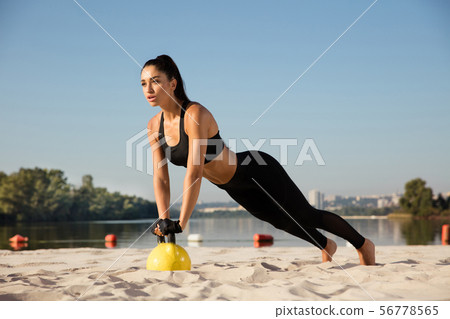 Young healthy female athlete doing workout at the beach 56778565