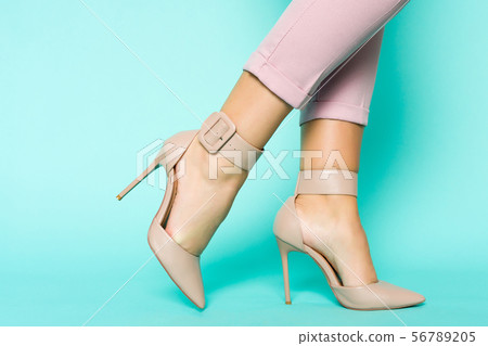 Sexy legs in brown high heels shoes on blue 56789205