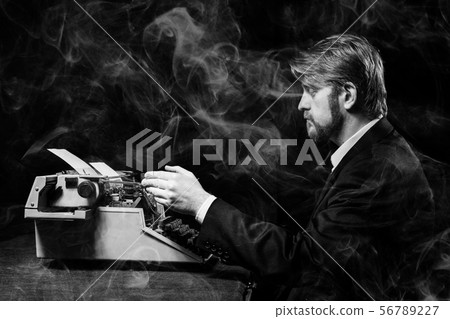 writer, man in a black jacket typing on typewriter 56789227