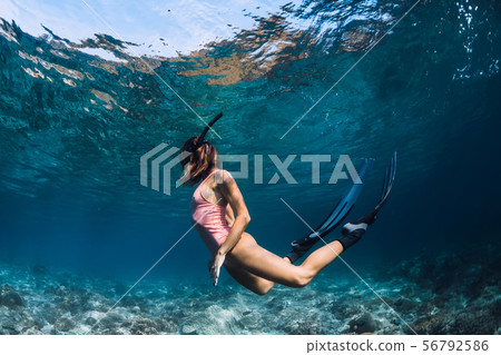 Woman freediver swim in pink swimsuit underwater 56792586