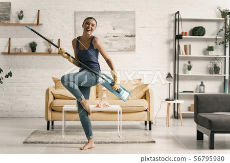 Funny housewife dancing with mop during housework Funny housewife dancing with mop during housework 56795980