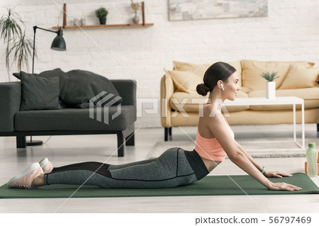 Smiling woman practicing yoga at home stock photo 56797469