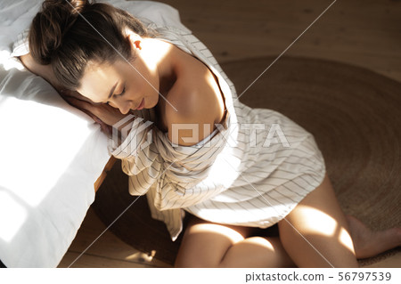 Pretty lady sitting on the floor next to bed and sleeping Pretty lady sitting on the floor next to bed and sleeping 56797539