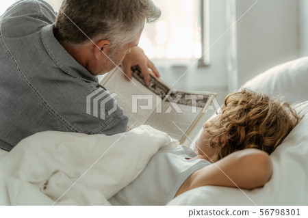 Father reading book with son in morning 56798301