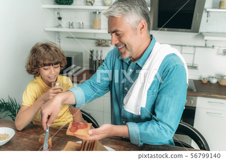 Father with son making toast on breakfast 56799140