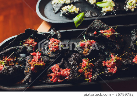 crackers with cream cheese and black caviar, horizontal. 56799782