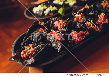 crackers with cream cheese and black caviar, horizontal. 56799783