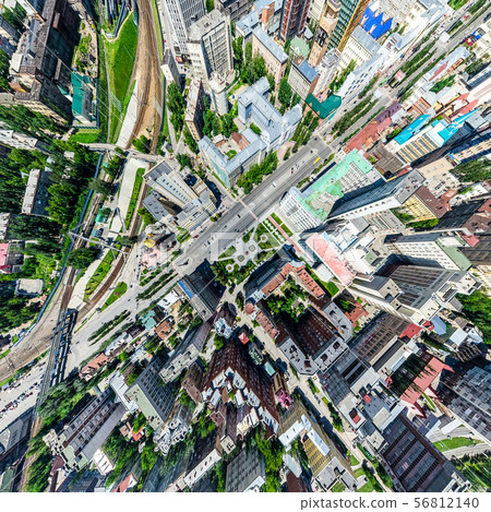 Aerial city view with crossroads and roads, houses, buildings, parks and parking lots. Sunny summer 56812140