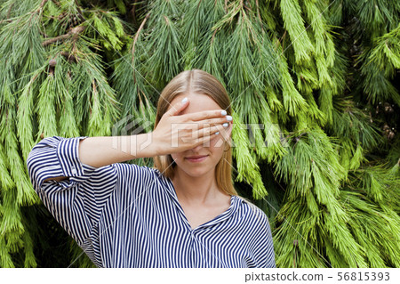 Woman wearing elegant clothes hiding her face 56815393