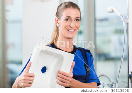 Female worker at work in a sanitary shop with high-quality ceramic fixtures Female worker at work in a sanitary shop with high-quality ceramic fixtures 56815908