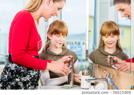 Woman checking a bathroom sink faucet in a modern sanitary ware shop 56815909